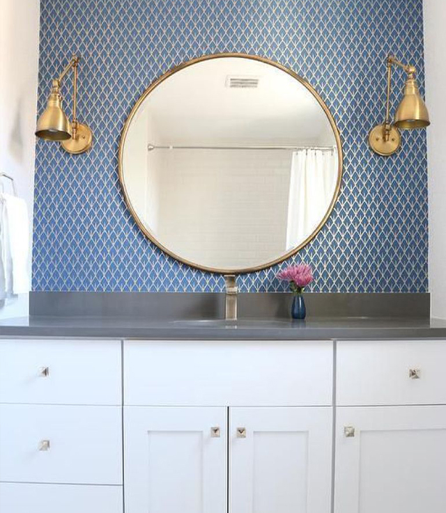 Круглое зеркало в металлической раме в интерьере ванной
